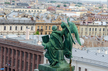 St. Petersburg, Russia - June 12, 2025: Sculpture of the Evangelist Matthew with an Angel on the roof of the southern facade of St. Isaac's Cathedral