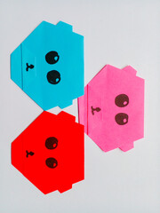 Origami blue, red and pink bear head isolated on white background.
