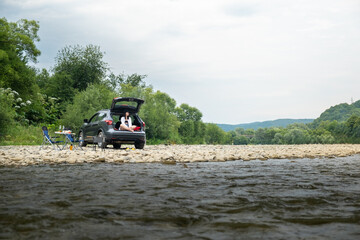 Camping near Mountain River Woman in Car Trunk