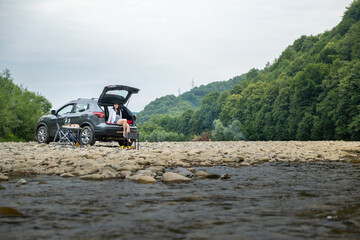 Camping near Mountain River Woman in Car Trunk