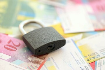 Swiss franc banknotes and padlock. The current francs money bills with lock lies in big amount