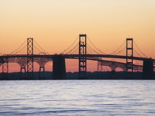 Suspension bridge at sunset over the water