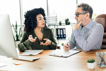 Professional discussion between coworkers in a modern office setting emphasizing collaboration and...