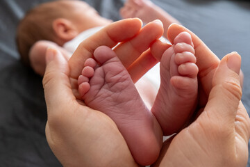 Tender Moment: Adult Hands Holding Newborn Baby Feet