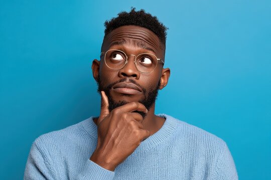 Black Guy Confused. Professional Man in Glasses Imagining Solutions and Thinking over Blue Background