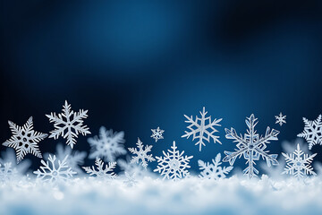 Close up of detailed snowflakes scattered on a snowy surface with a dark blue background