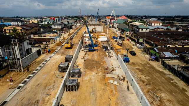 Aerial view of a construction site reveals the skeletal framework of a new bridge, cutting a path through the urban landscape, Port Harcourt, Rivers, Nigeria.
