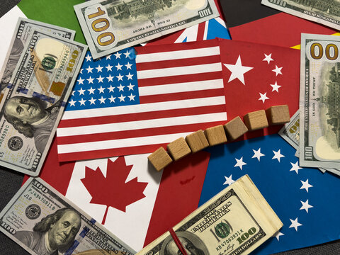 Wood cube tariffs word on Flag of the United States of America background. Tariff US trade war with Canada and Mexico.