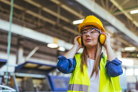 Female Worker in Safety Gear at an Industrial Factory Setting