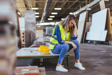 Female Worker Feeling Stressed While Sitting in a Construction Workshop