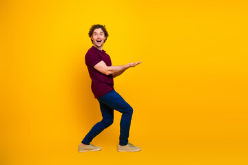 Excited young man in casual outfit gesturing with enthusiasm against a vibrant yellow backdrop conveying positivity