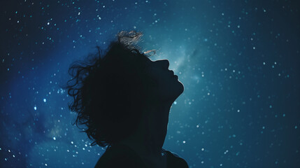 Silhouette of a person in profile under a starry night sky