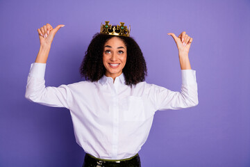 Confident businesswoman wearing a crown and pointing at herself on a vibrant purple background