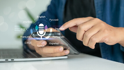 Hand using smartphone with multilingual AI voice assistant interface, supporting various languages...