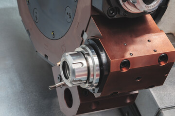 CNC Machine with a brown casing and a silver part.  machine is used for drilling. machine has a...