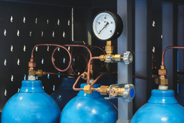 Blue oxygen tank with a black gauge on top. gauge is showing a pressure