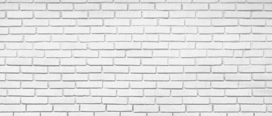 White brick wall with no visible writing. wall is made of white bricks. wall is very long and has...