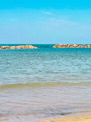 Panoramic view of beach, sea and sand in the summer sun. In the background, a beach area