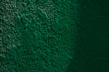 Close-up of textured green wall surface with shadows