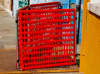 Red temporary fence in colorful urban alleyway