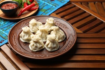 Delicious khinkali served on wooden table, space for text