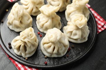 Delicious khinkali with spices on black table, above view