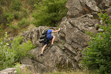 man in sports suit with backpack doing active sports on mountain
