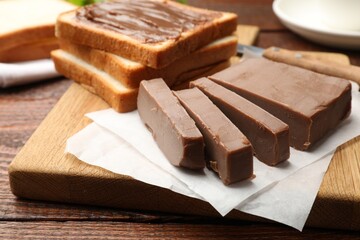 Sandwiches with chocolate butter on wooden table, closeup