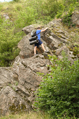 man in sports suit with backpack doing active sports on mountain