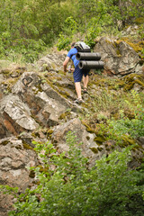 man in sports suit with backpack doing active sports on mountain