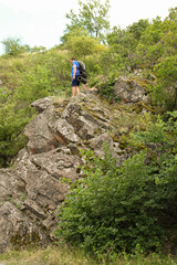 man in sports suit with backpack doing active sports on mountain