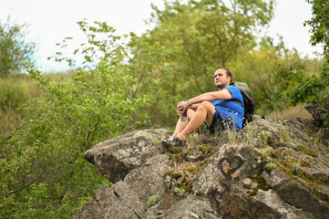 man in sports suit with backpack doing active sports on mountain