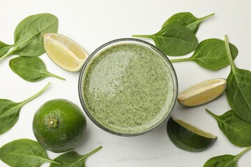 Tasty spinach smoothie and ingredients on white table, flat lay