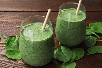 Tasty smoothie and spinach leaves on wooden, closeup