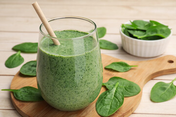 Tasty smoothie and spinach leaves on white wooden, closeup