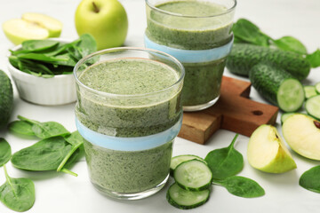 Tasty smoothie and spinach leaves on white marble table, closeup