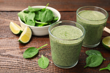 Tasty spinach smoothie and ingredients on wooden table, closeup