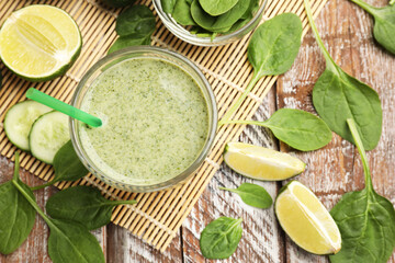 Tasty spinach smoothie and ingredients on wooden table, flat lay