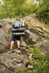 man in sports suit with backpack doing active sports on mountain