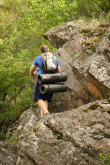 man in sports suit with backpack doing active sports on mountain