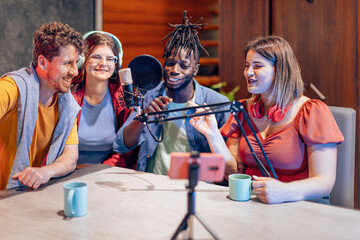 Content creators recording podcast in home studio using smartphone and microphone