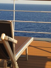Tumbona vacía junto al mar en cubierta de barco de crucero
