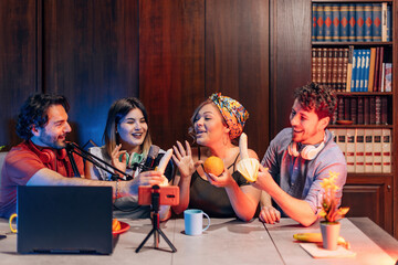 Content creators having fun during a live podcast, holding bananas and oranges