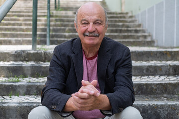 Elderly Man Sitting on Stair Steps, Resting and Remembering His Youth