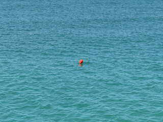 Solitary Orange Buoy Floating on Calm Open Water
