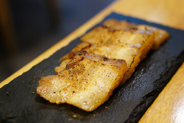 Close-up of Sliced Seasoned Pork Belly on Slate Plate