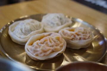 Close-up of Juicy Steamed Kimchi and Meat Dumplings on a Plate in a Korean Restaurant