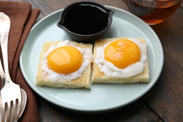 Tasty kaya toasts with half-boiled eggs served on wooden table, closeup. Traditional asian breakfast