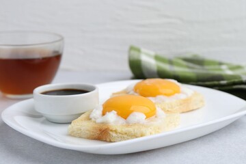 Tasty kaya toasts with half-boiled eggs served on light grey table, closeup. Traditional asian breakfast