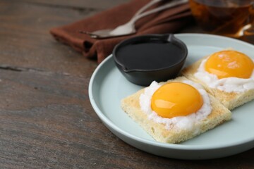 Traditional asian breakfast with tasty kaya toasts and half-boiled eggs served on wooden table, closeup. Space for text
